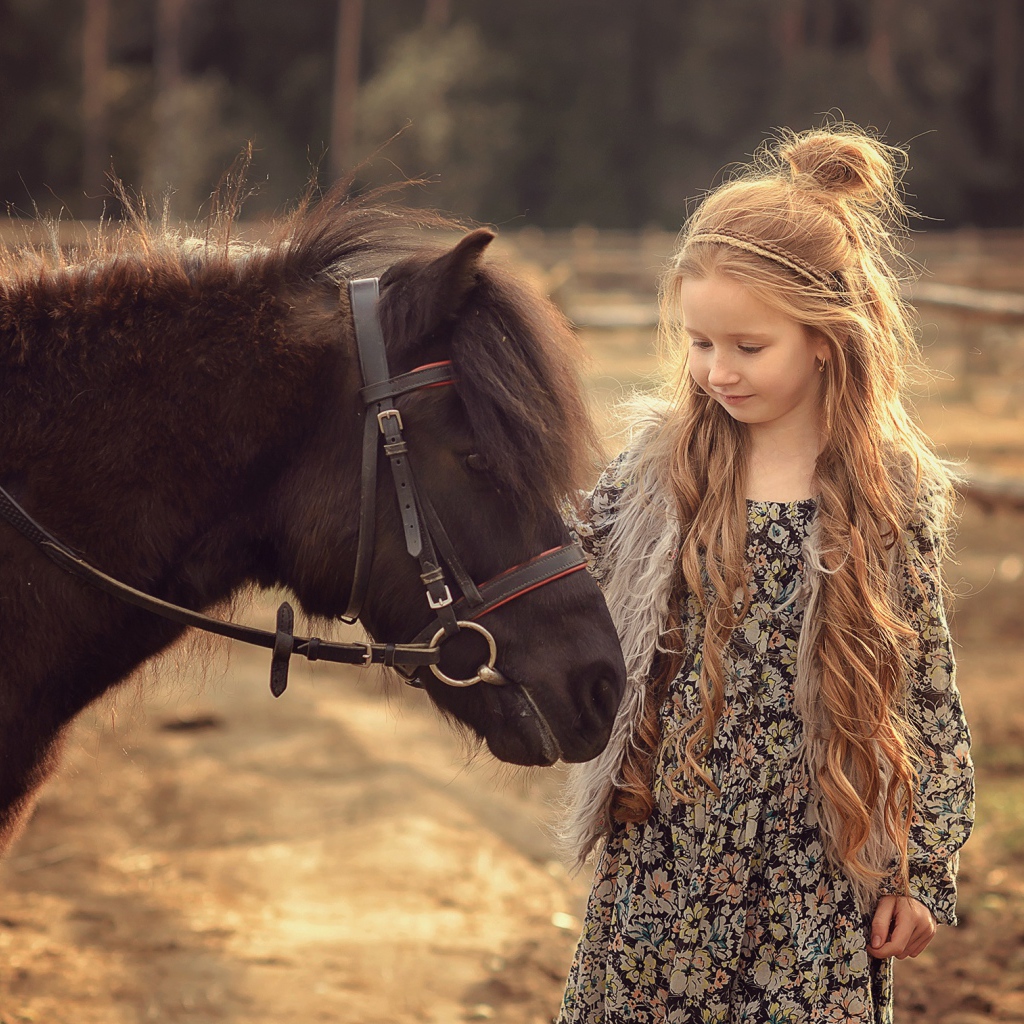 Маленькая девочка с пони на ферме