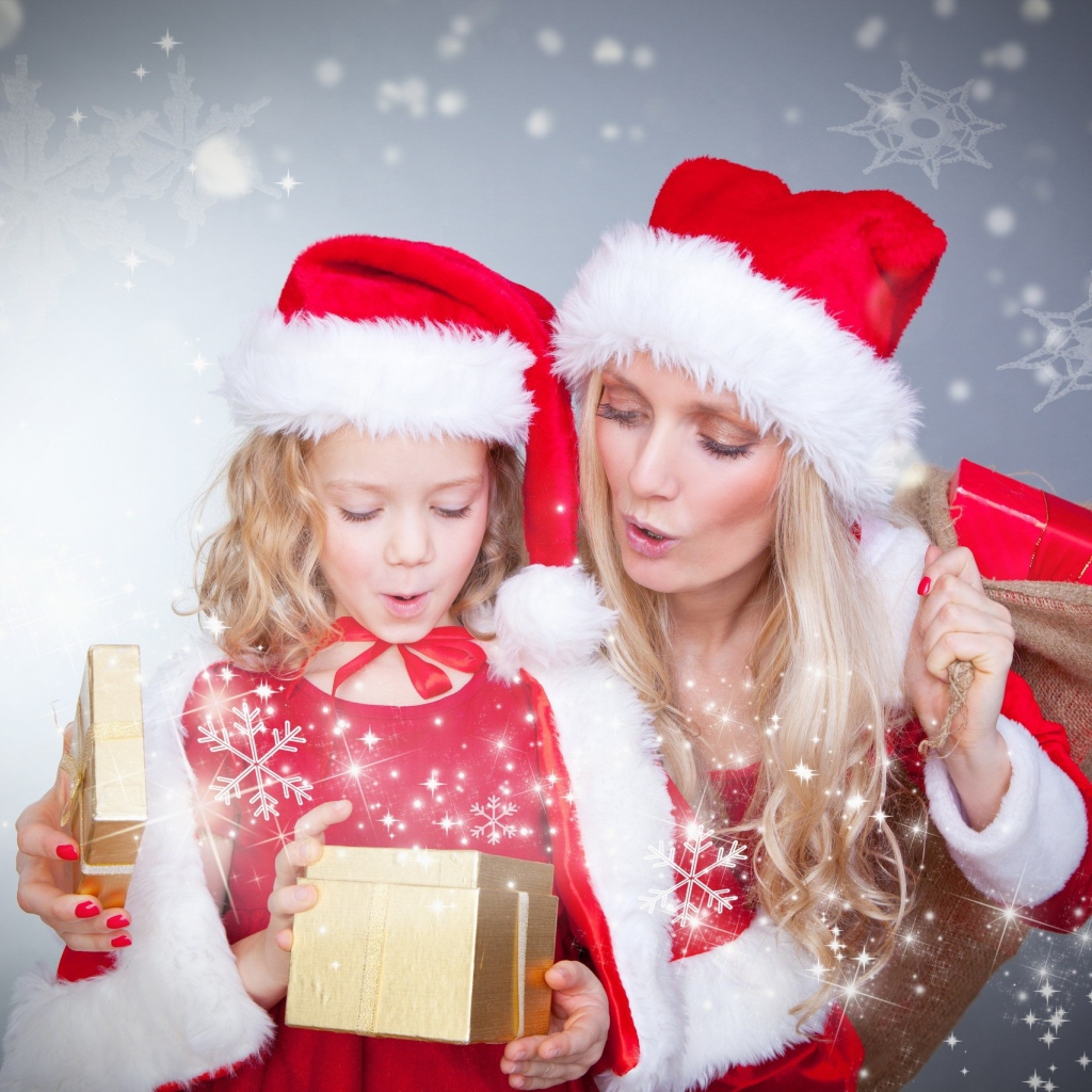 Маленькая девочка с мамой в новогодних костюмах с подарками