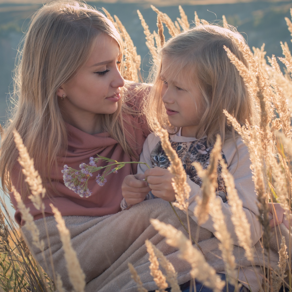 Маленькая девочка с мамой на поле с колосками 