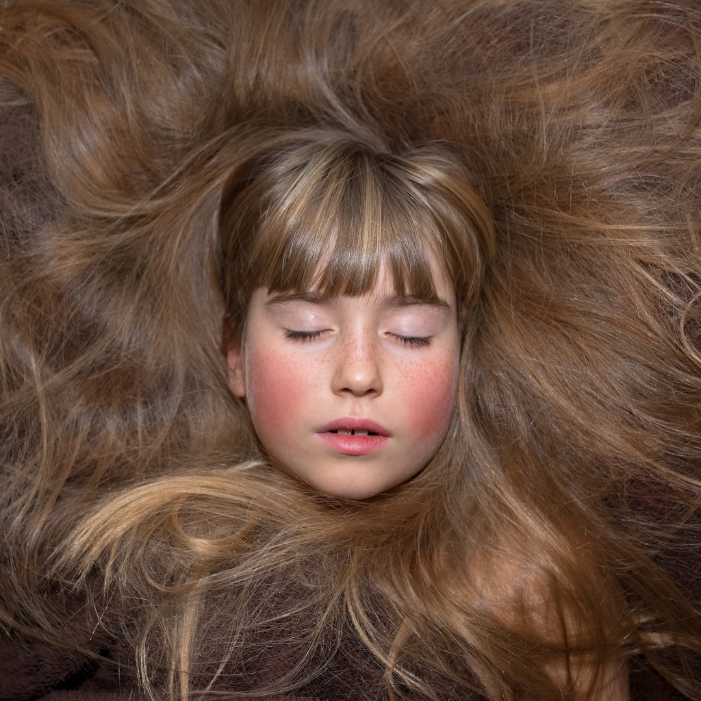 Маленькая спящая девочка с длинными волосами