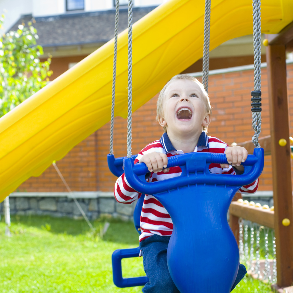 Улыбающийся ребенок на качели 