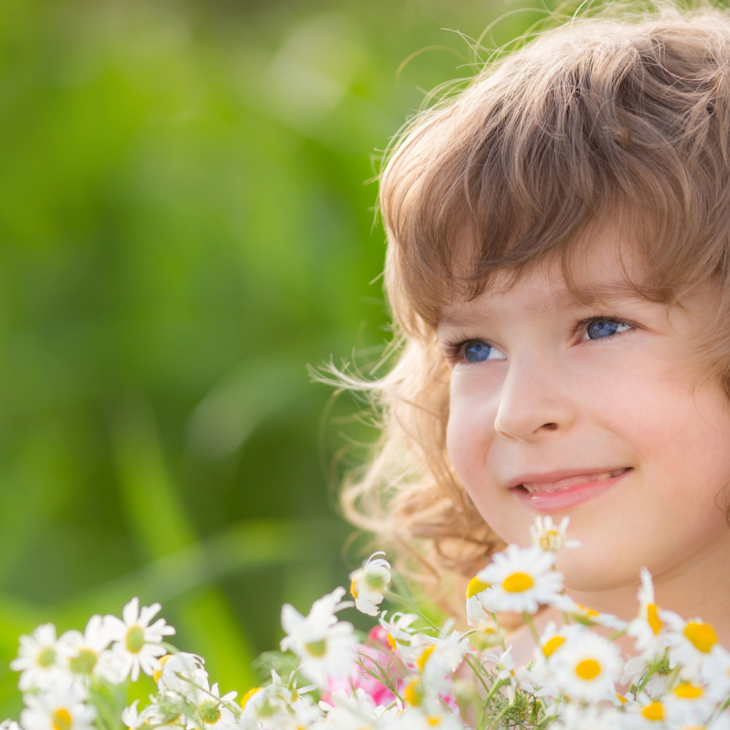Улыбающаяся девочка с букетом ромашек 