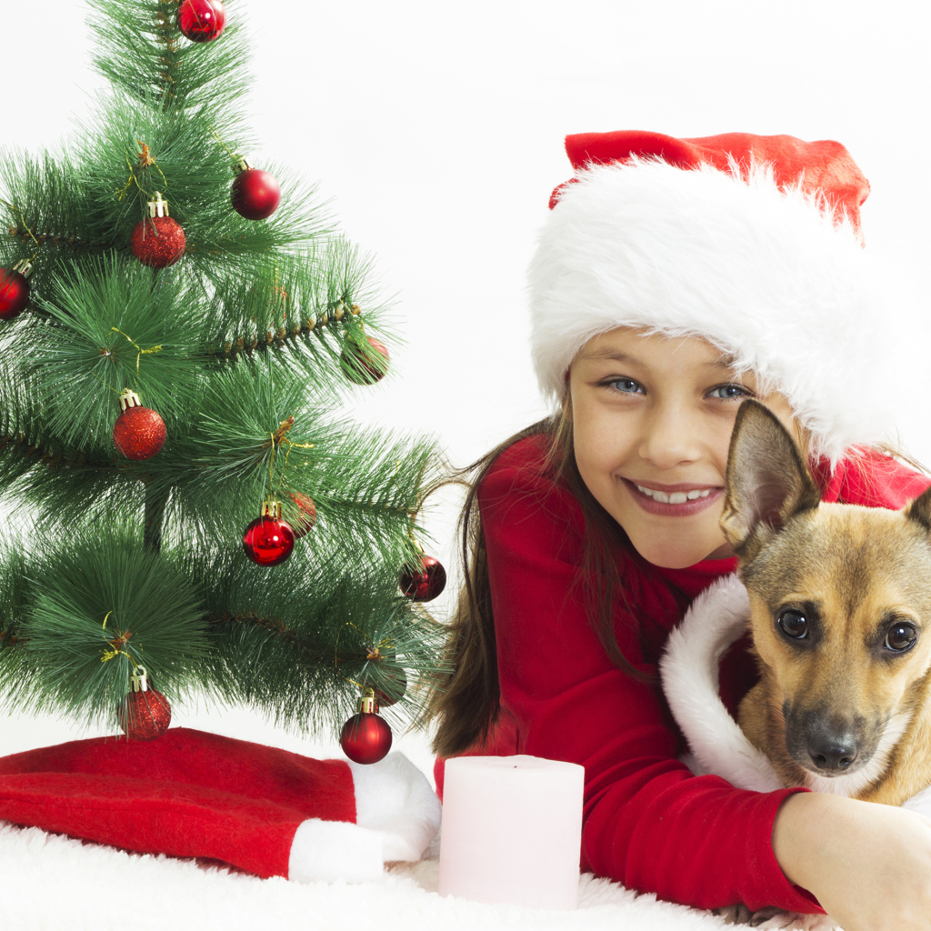 Улыбающаяся девочка с собакой у зеленой елки
