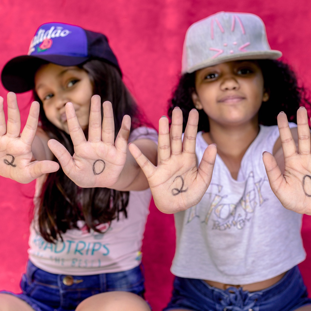 Две маленькие девочка с цифрами на ладонях 