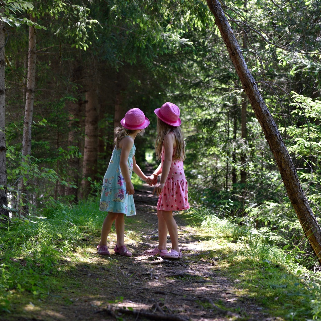 Две маленькие девочки гуляют в лесу