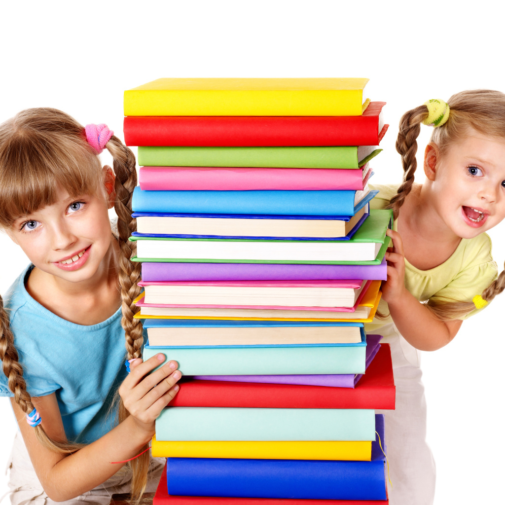 Две маленькие девочки с разноцветными книгами на белом фоне