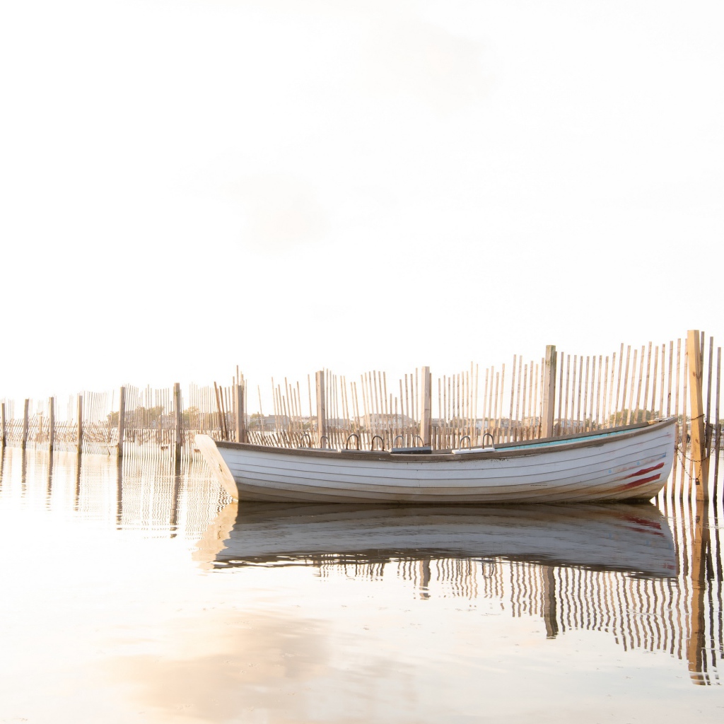 Лодка в воде у ограждения 
