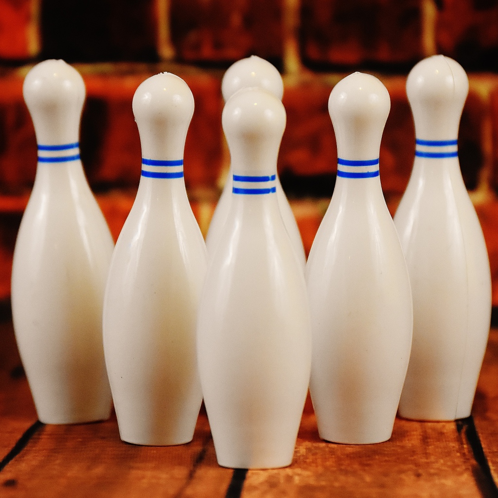 Белые кегли стоят у стены 