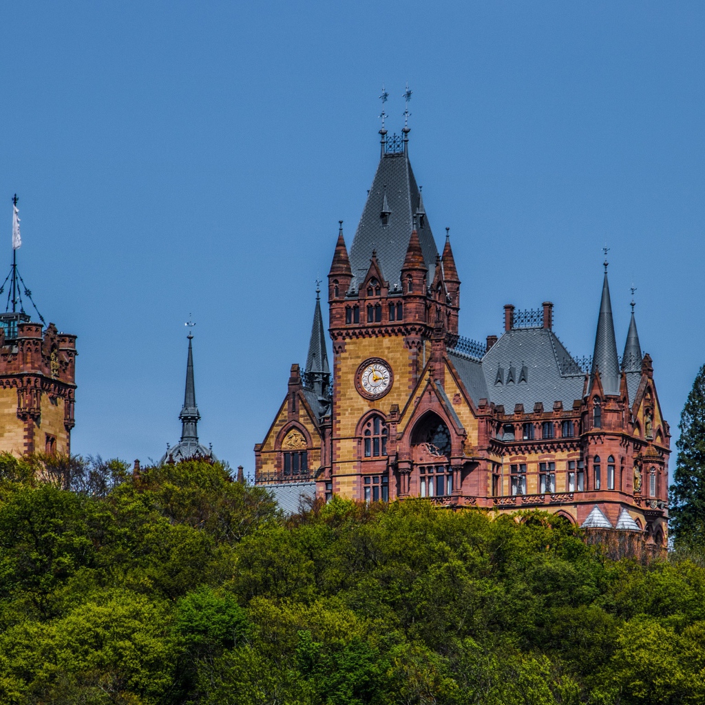Замок Драхенбург в зарослях деревьев под голубым небом
