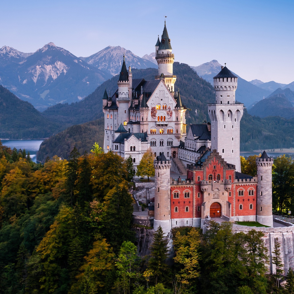 Замок Нойшванштайн в лесных зарослях на фоне гор, Германия 