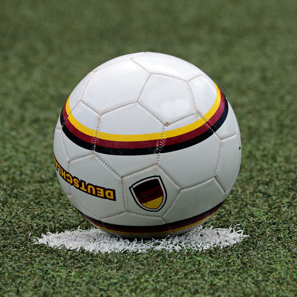 Футбольный мяч лежит на метке на поле 
