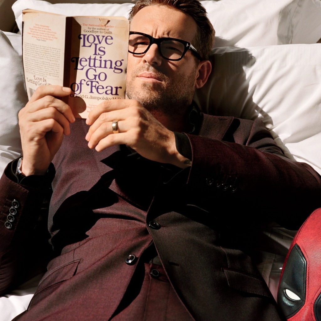 Актер Райан Рейнольдс лежит с книгой на кровати