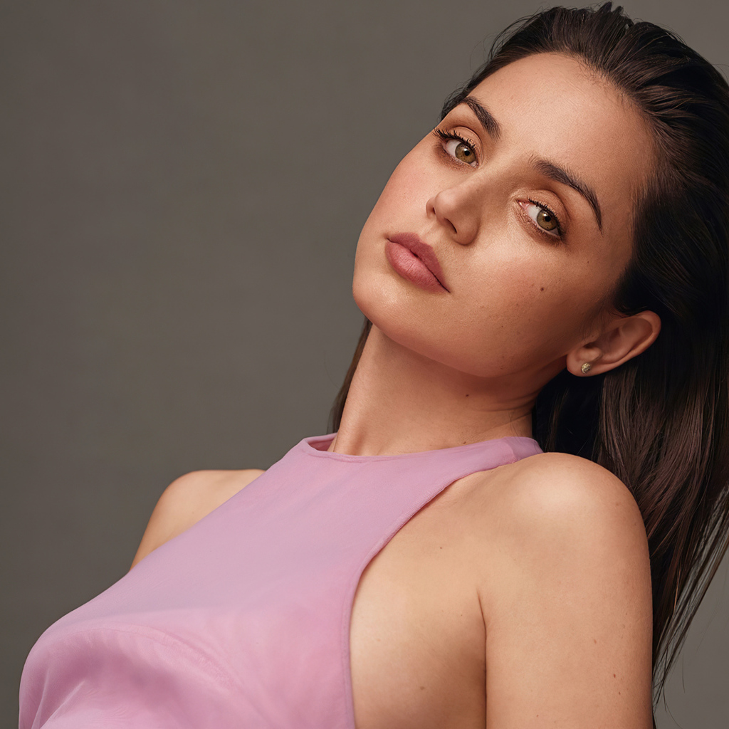 Актриса Ана де Армас на сером фоне в розовой кофте