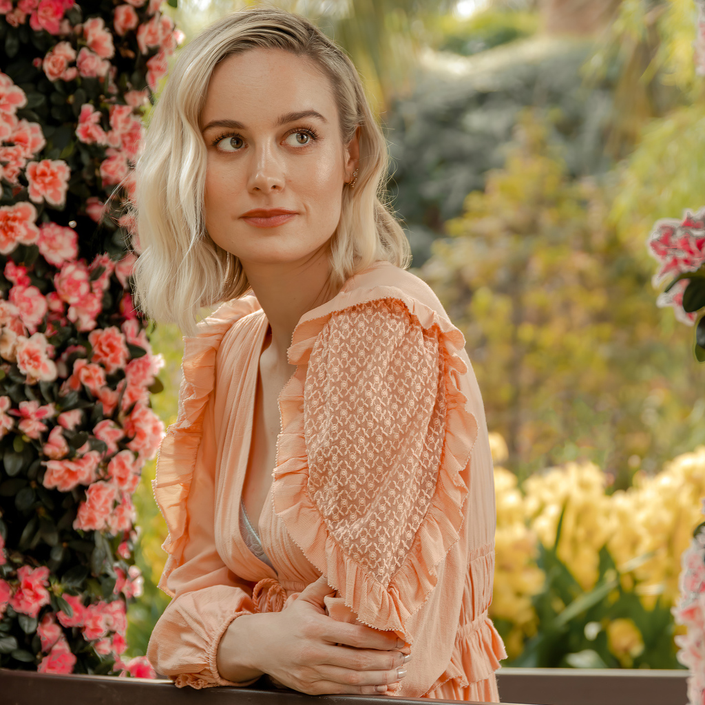 Актриса Бри Ларсон сидит у кустов с розовыми цветами