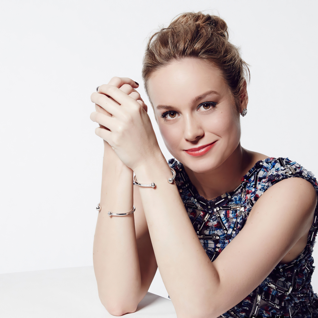 Актриса Бри Ларсон с милой улыбкой на белом фоне