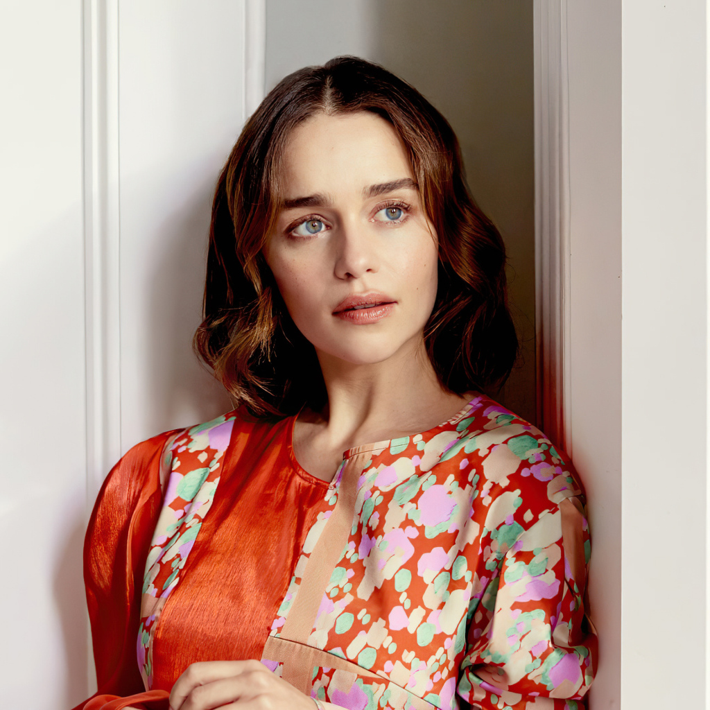 Актриса Эмилия Кларк в платье стоит у стены