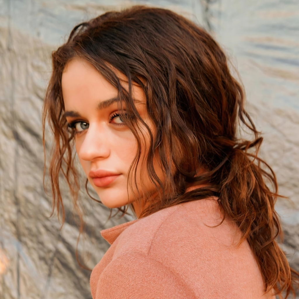 Актриса Джои Кинг стоит боком у стены 