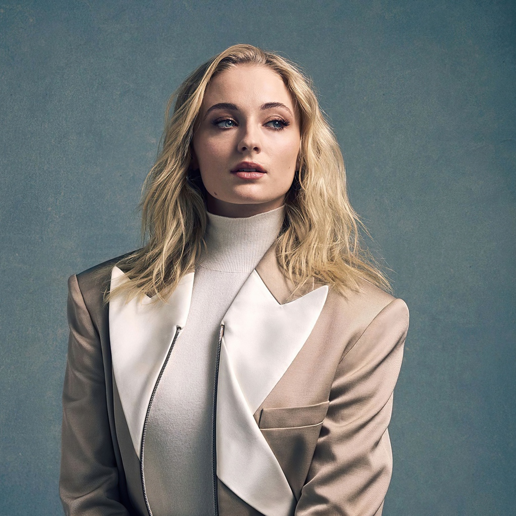 Актриса Софи Тёрнер в бежевом костюме на сером фоне