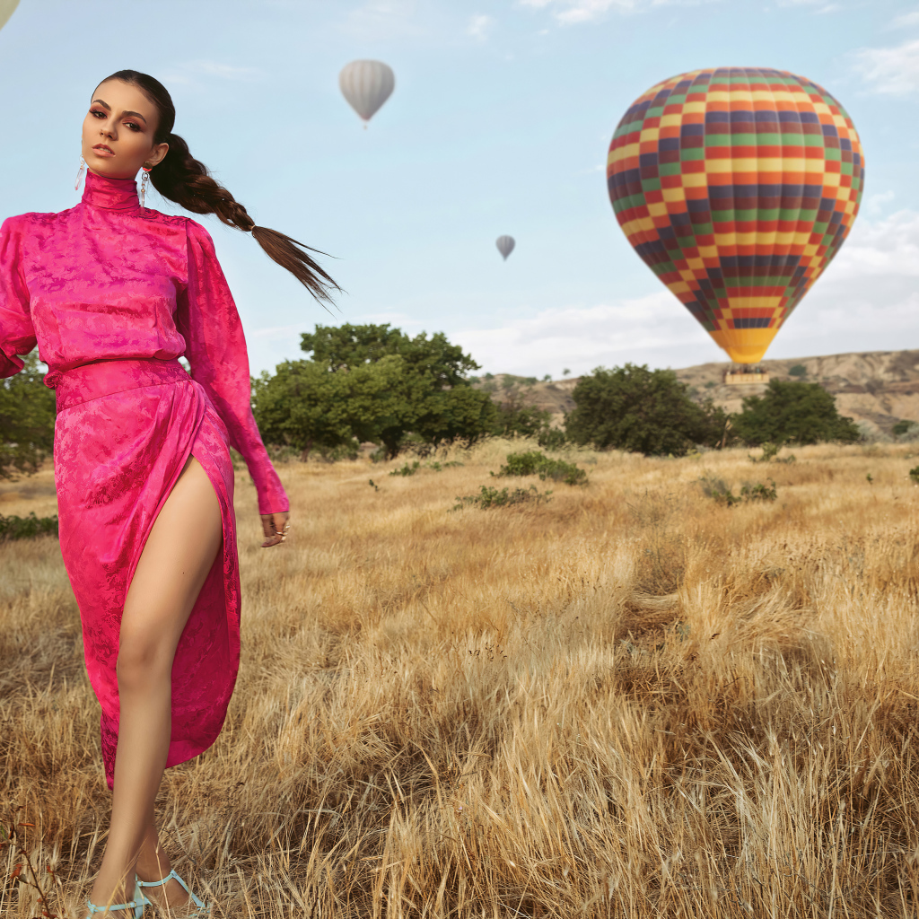 Актриса Виктория Джастис в красном платье на поле с воздушными шарами 