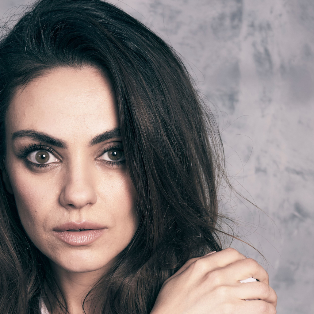 Американская актриса Мила Кунис на сером фоне