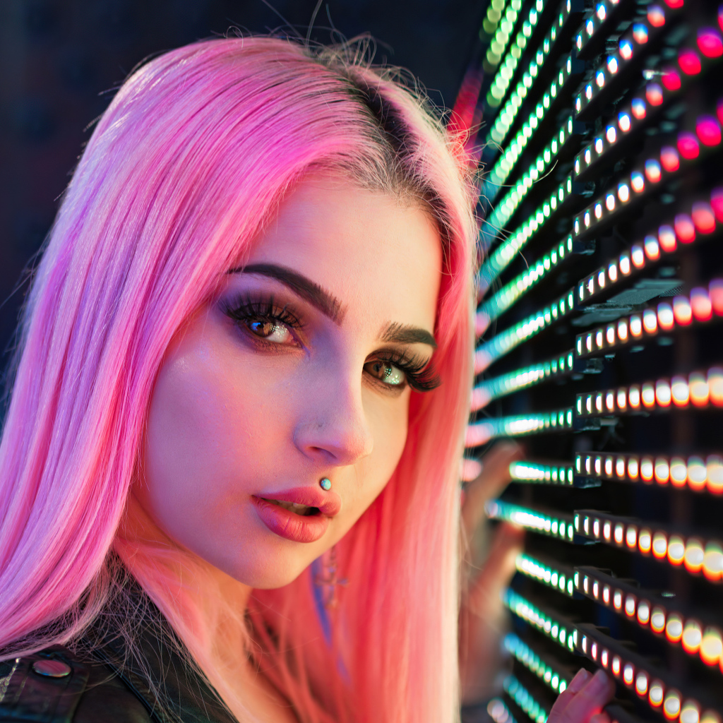 Красивая девушка с розовыми волосами с лампочками на стене 