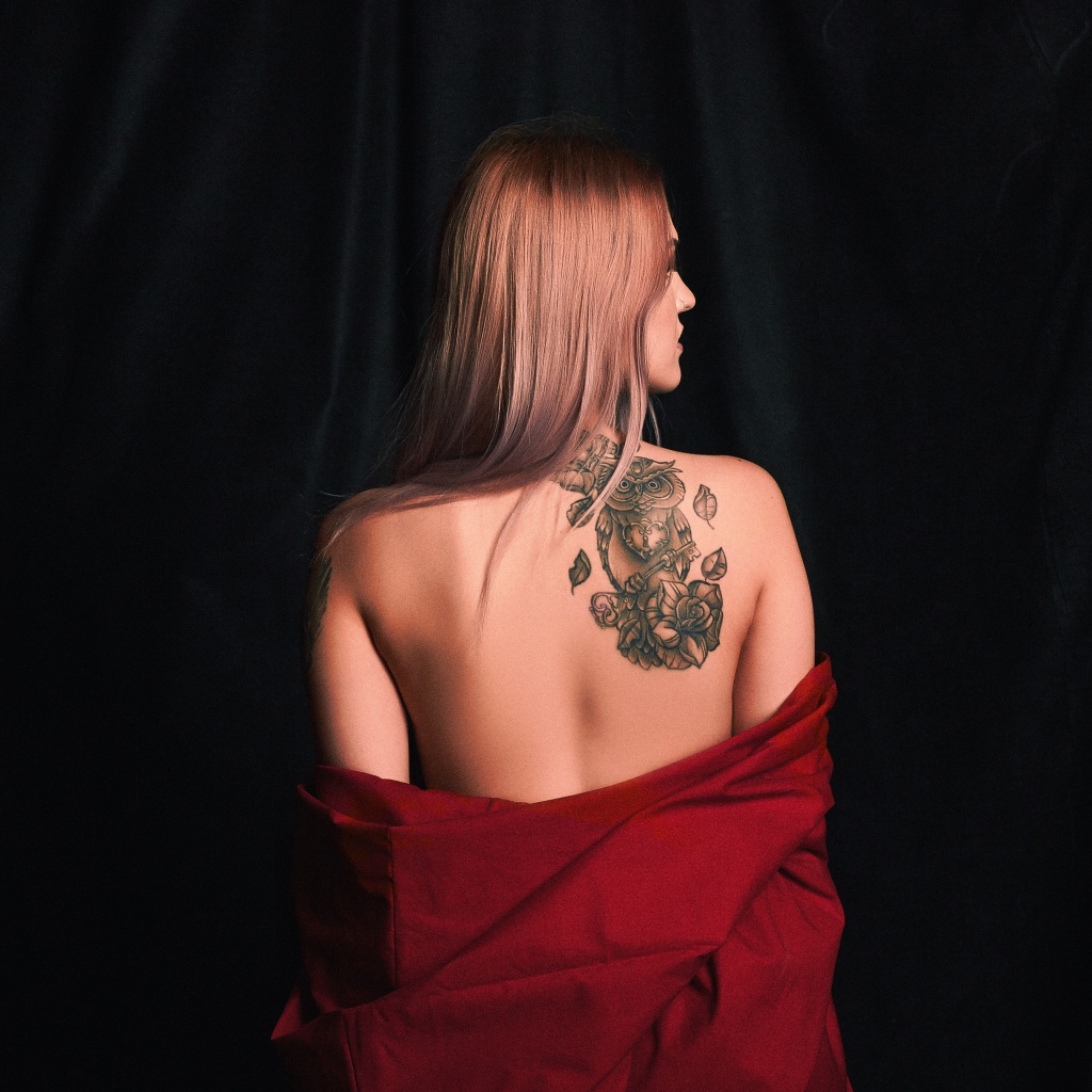 Красивая татуировка совы на спине у молодой девушки