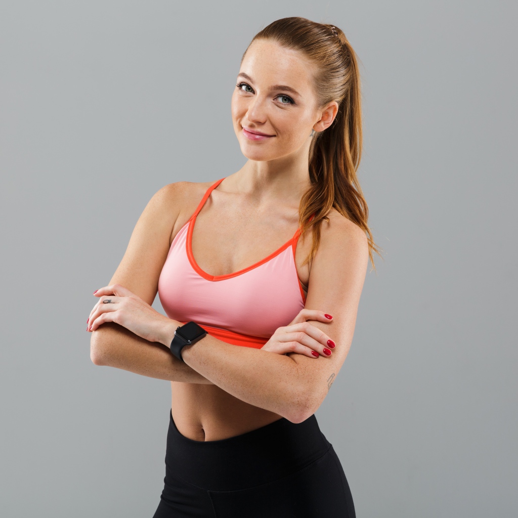 Красивая стройная спортивная девушка на сером фоне