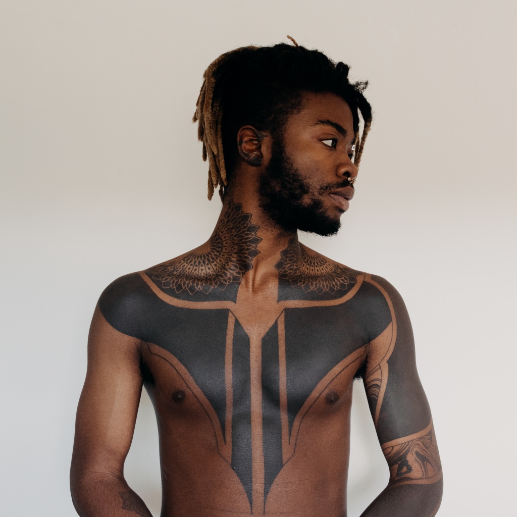 Темнокожий мужчина с татуировками на теле