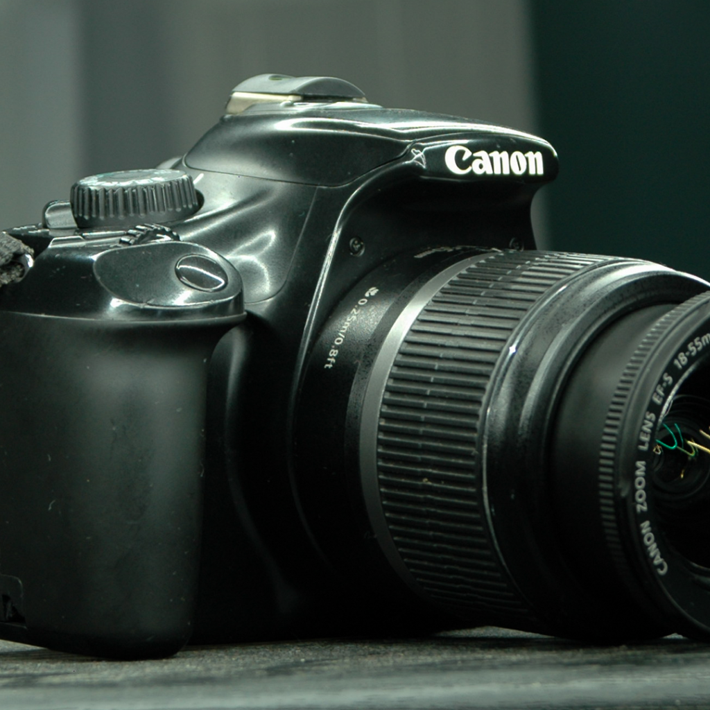 Фотоаппарат Canon 1100D лежит на столе