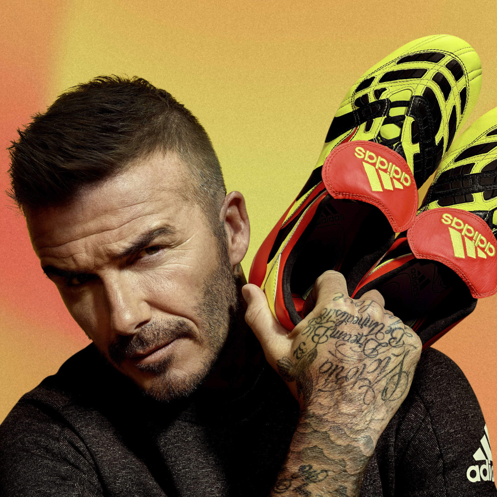 Футболист Дэвид Бекхэм с кедами Адидас в руке