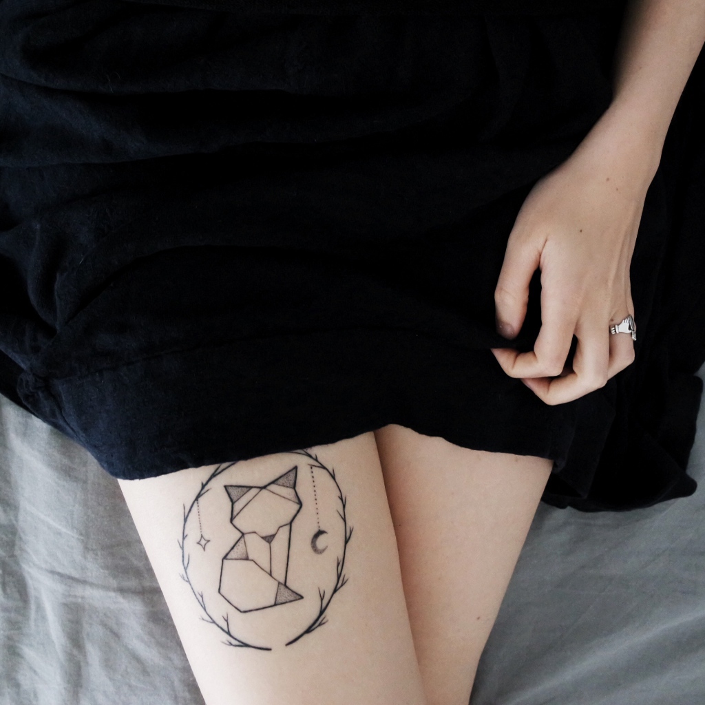 Татуировка лиса на ноге у девушки в черном платье