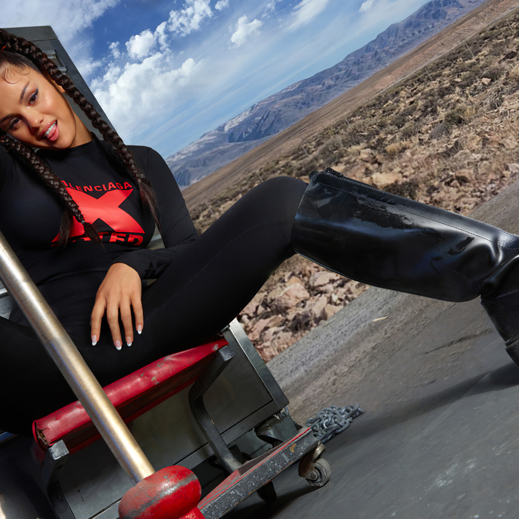 Смешная девушка, певица и актриса Селена Гомес сидит на стуле