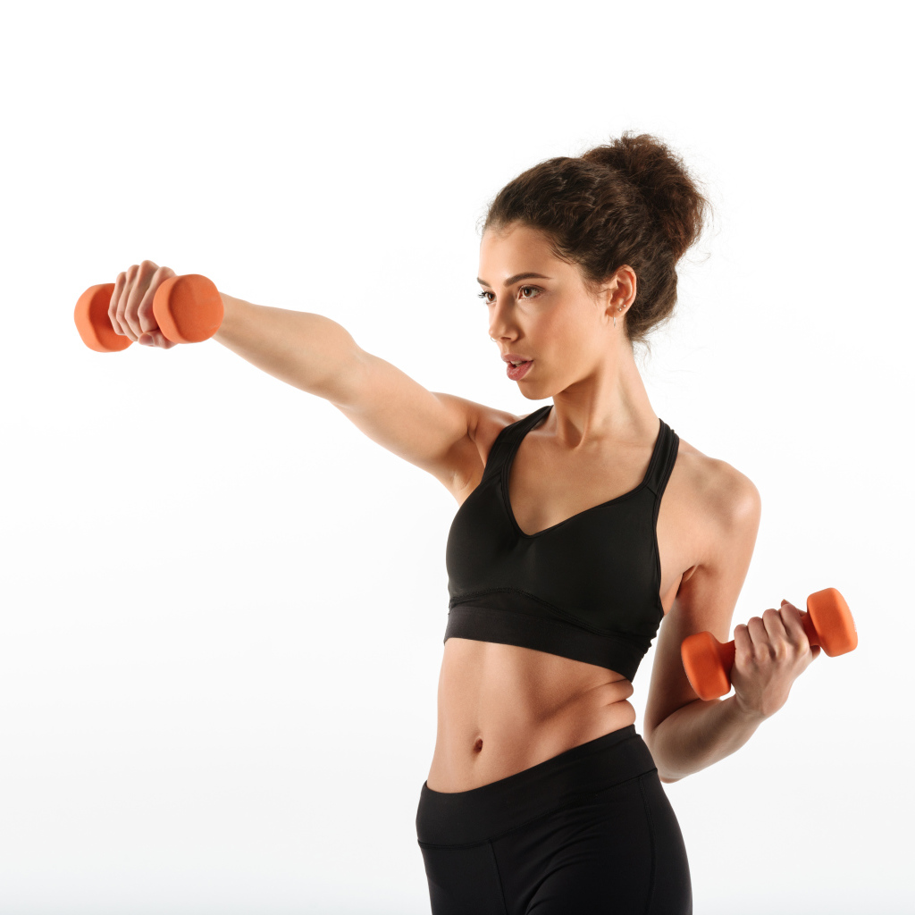Девушка в черном костюме качает руки гантелями