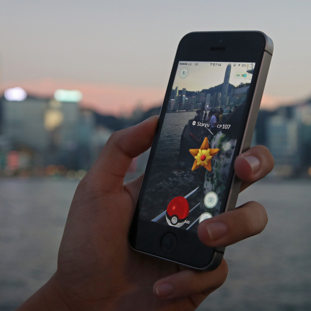 Парень ловит покемонов на смартфоне 