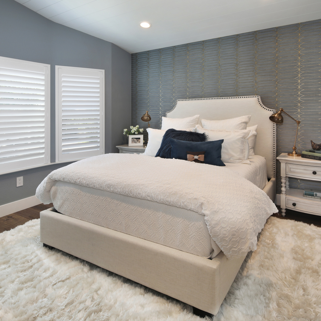 Высокая кровать в спальной комнате в серых тонах