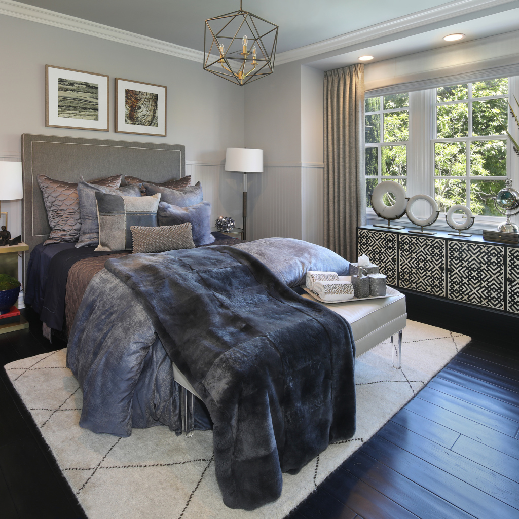 Large bed with soft gray bedspread in the bedroom
