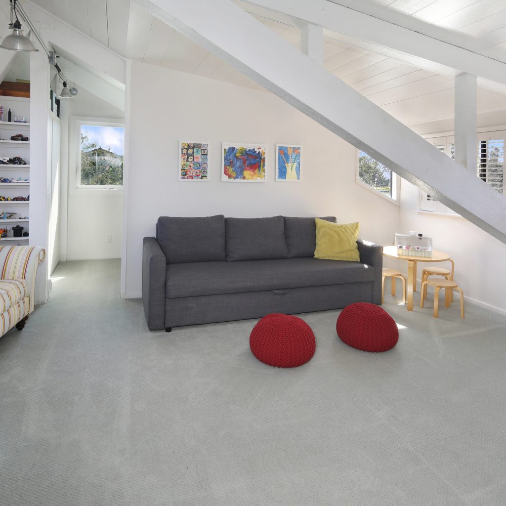 Большой серый диван в белой гостиной комнате