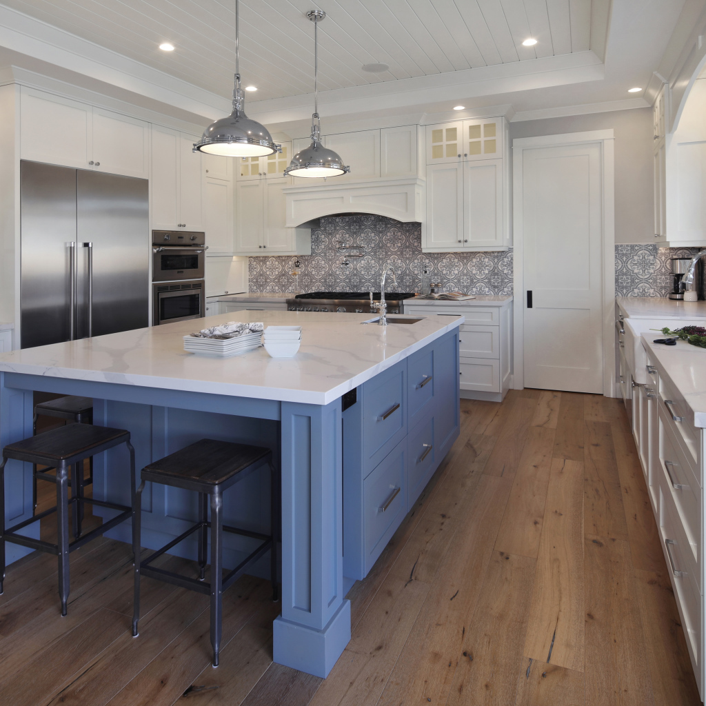 Большой серый стол в просторной белой кухне 