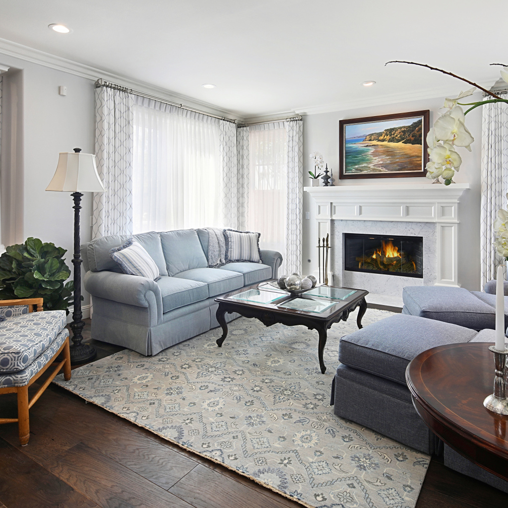 Большая гостиная комната с камином и живыми цветами