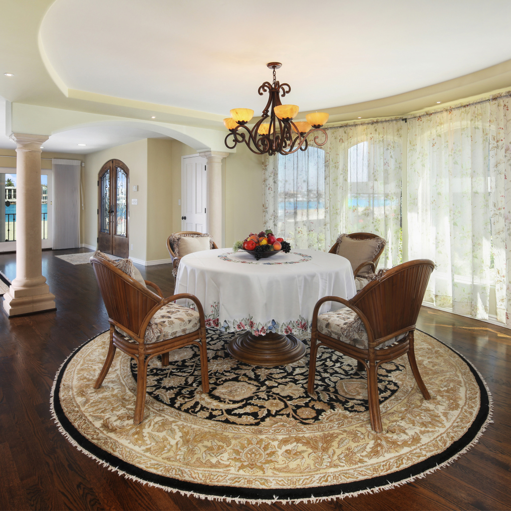 Большая гостиная комната с большими окнами и столом 