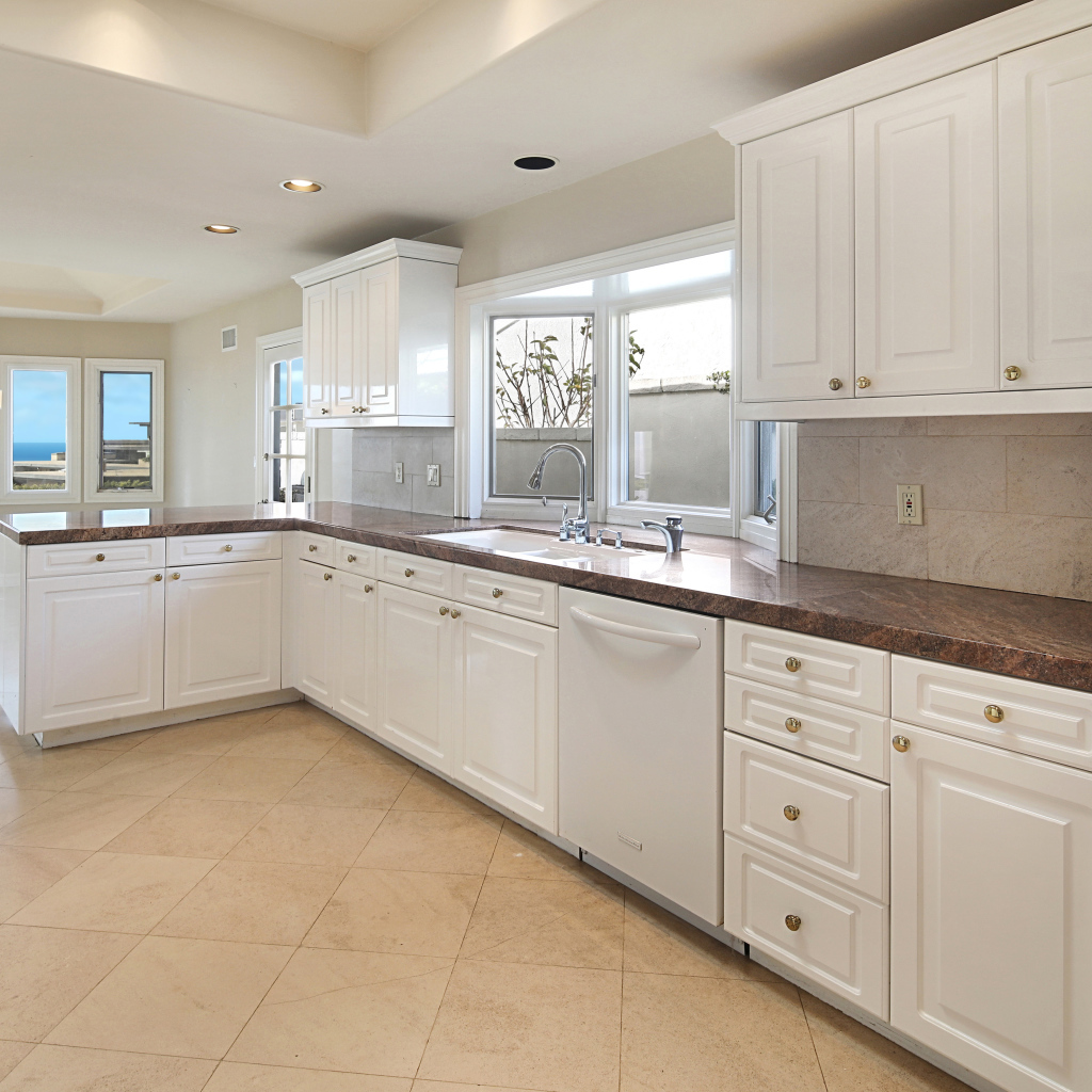 Большая белая кухня с окнами 