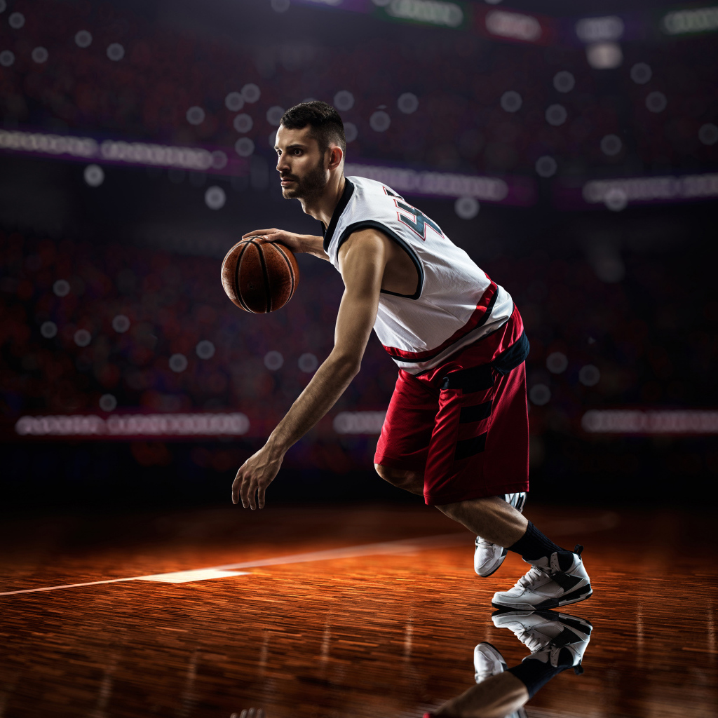 Мужчина баскетболист отбивает мяч на поле 