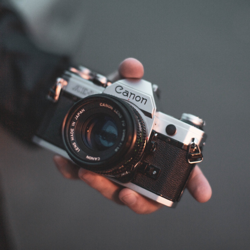 Старый фотоаппарат  Canon в руке 
