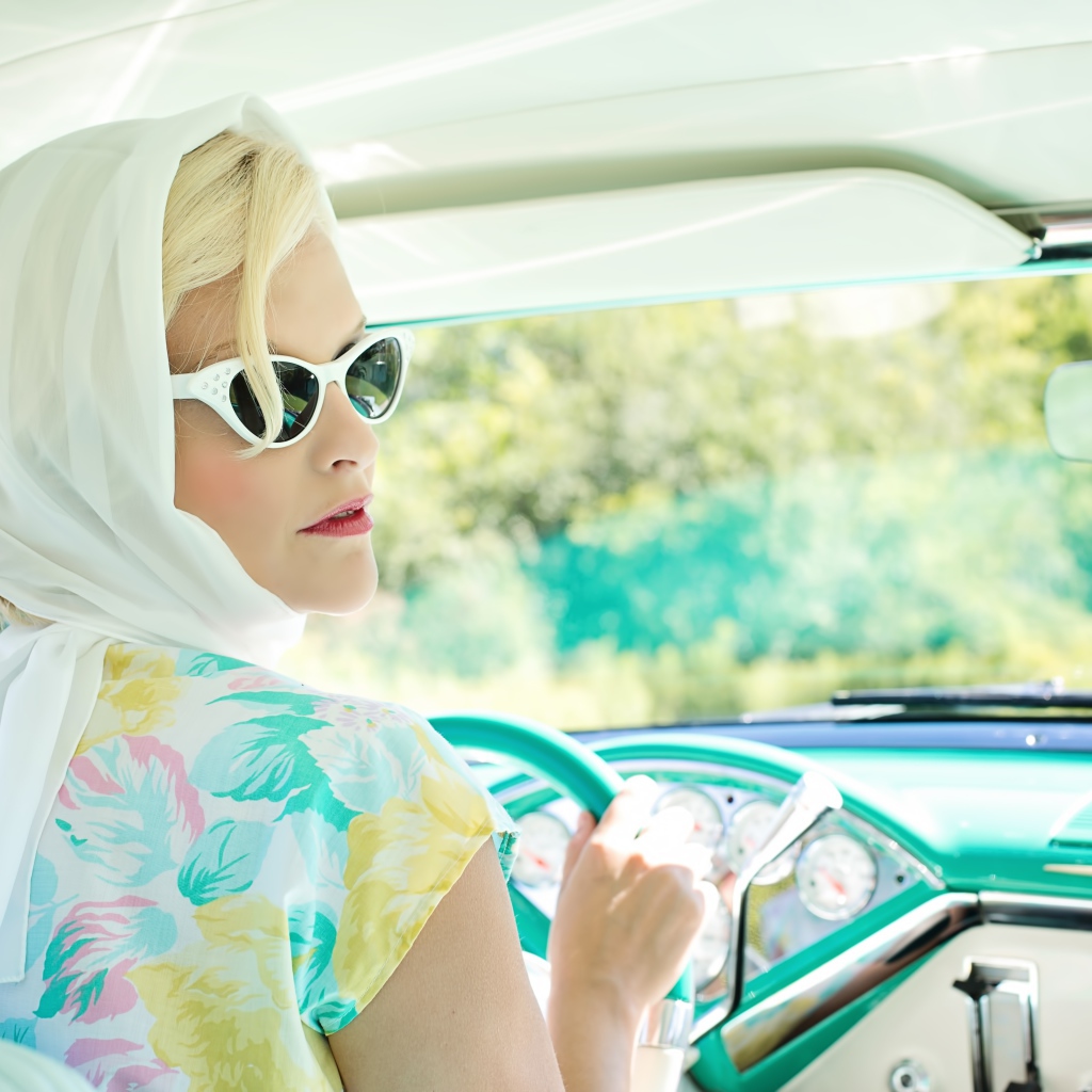 Ретро девушка в очках в старом автомобиле