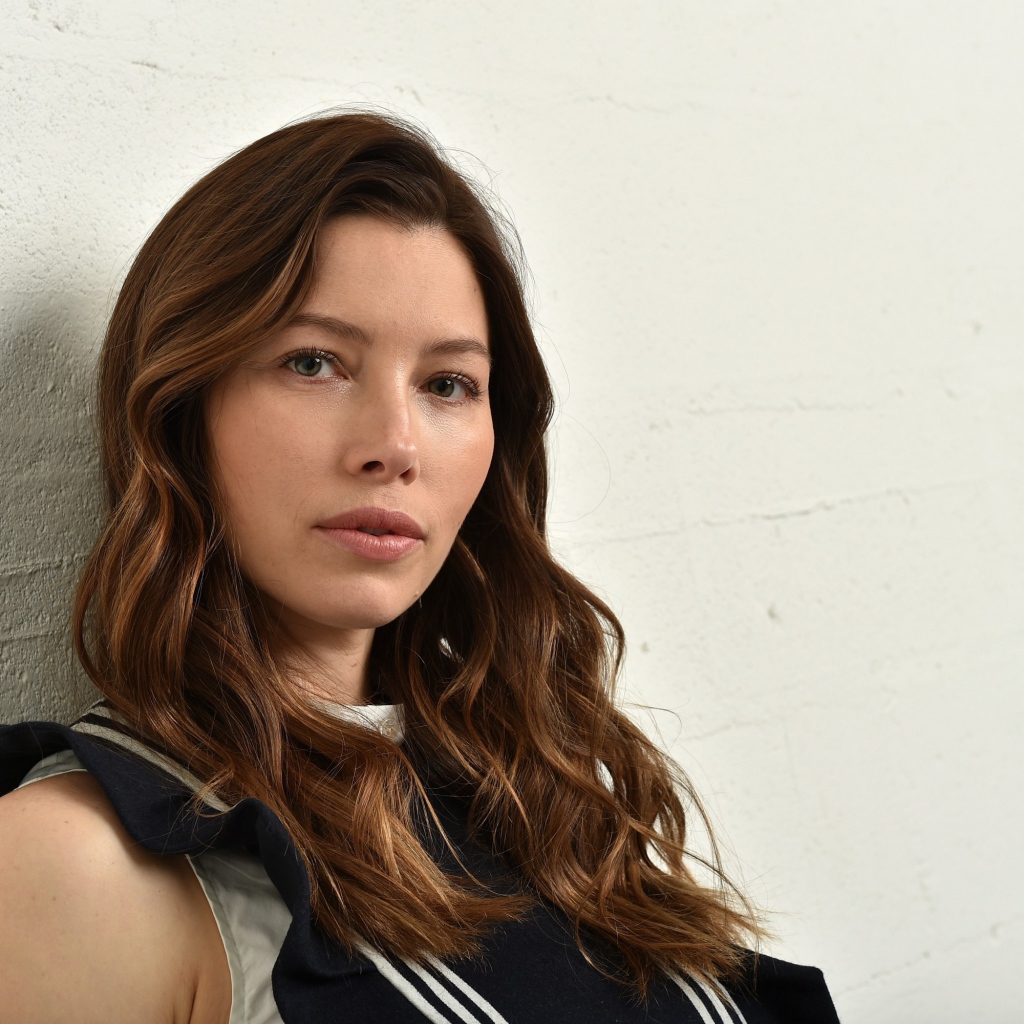 Грустная актриса Джессика Бил сидит у стены