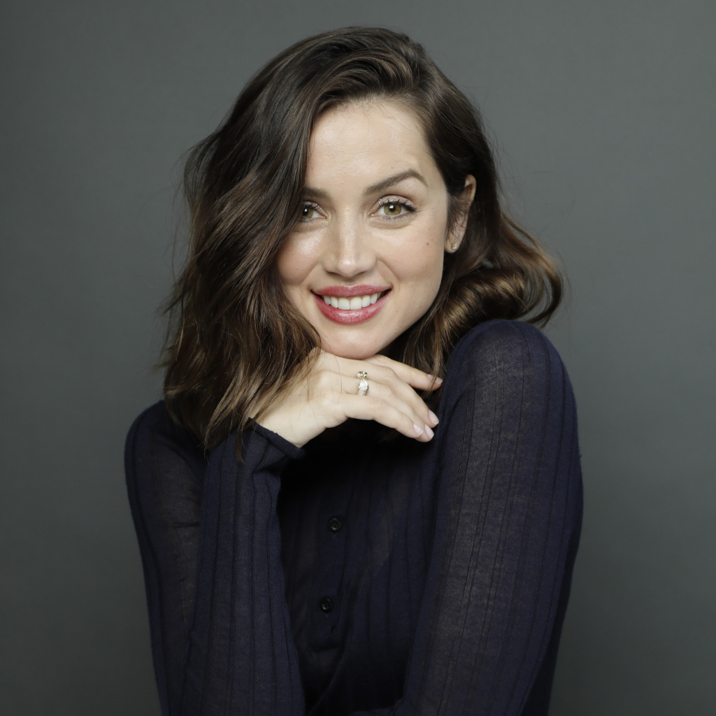 Улыбающаяся актриса Ана де Армас на сером фоне