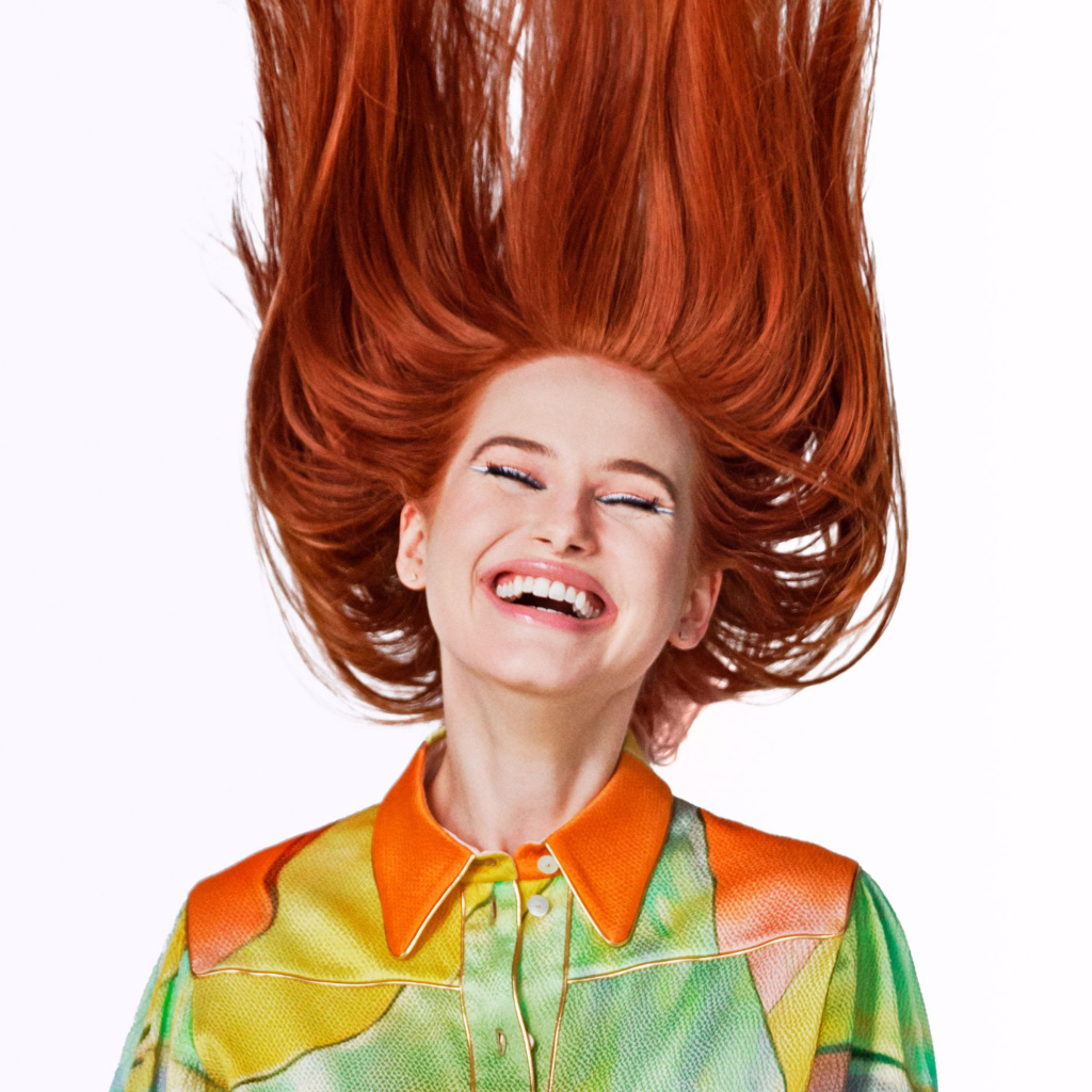 Улыбающаяся актриса Мэделин Петш с рыжими волосами на белом фоне