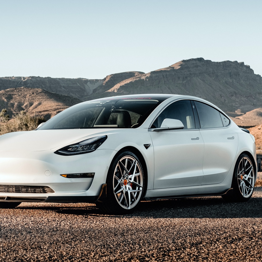 Белый автомобиль Tesla Model 3 Volta 2019 года на фоне гор 