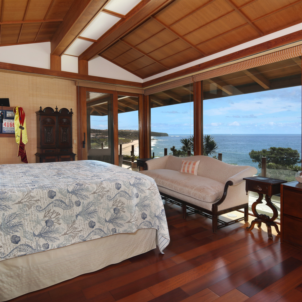 Деревянная спальня с большой кроватью и видом на море 