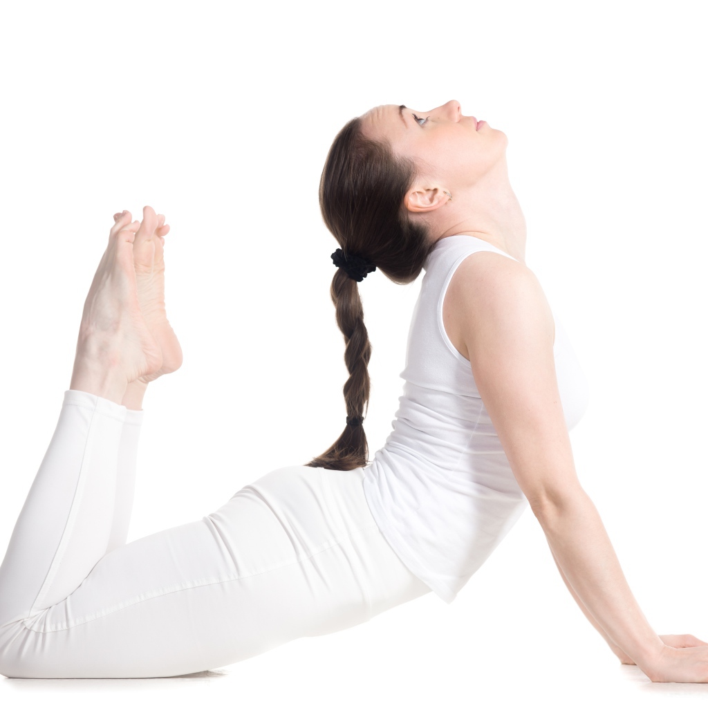 Молодая девушка делает растяжку на белом фоне